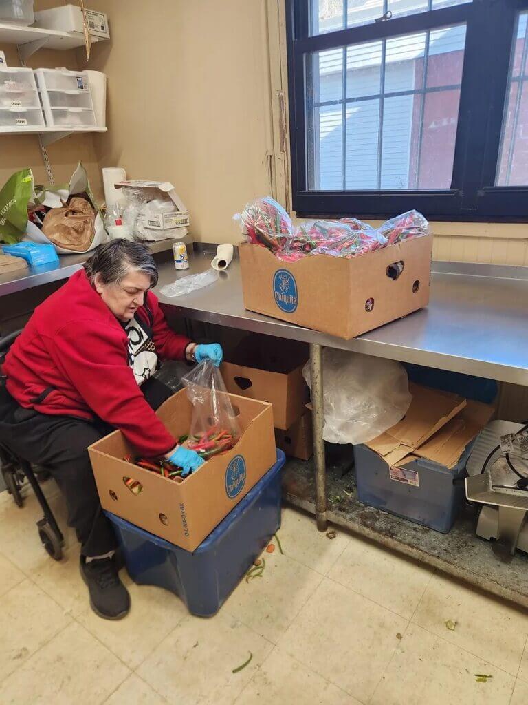 Volunteer processing donated fresh produce at Biddeford Food Pantry